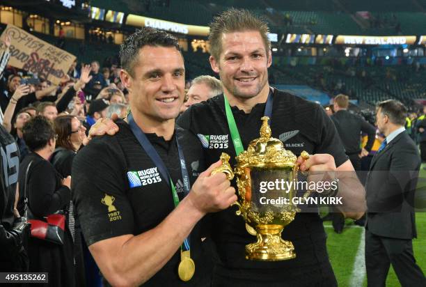 New Zealand's fly half Dan Carter and New Zealand's flanker and captain Richie McCaw celebrate with the Webb Ellis Cup after winning 34-17 during the...