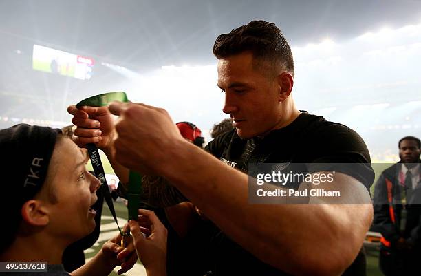 Sonny Bill Williams of New Zealand hands his medal to a young fan after winning the 2015 Rugby World Cup Final match between New Zealand and...