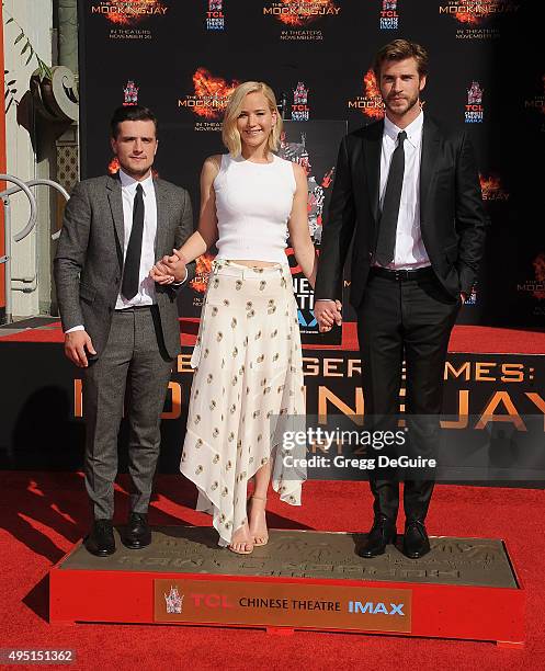 Actors Josh Hutcherson, Jennifer Lawrence and Liam Hemsworth pose at "The Hunger Games: Mockingjay - Part 2" Hand And Footprint Ceremony at TCL...