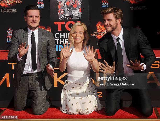 Actors Josh Hutcherson, Jennifer Lawrence and Liam Hemsworth pose at "The Hunger Games: Mockingjay - Part 2" Hand And Footprint Ceremony at TCL...