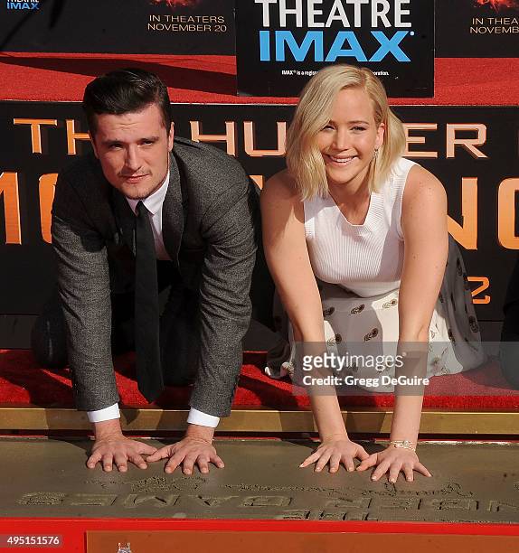 Actors Josh Hutcherson and Jennifer Lawrence pose at "The Hunger Games: Mockingjay - Part 2" Hand And Footprint Ceremony at TCL Chinese Theatre on...