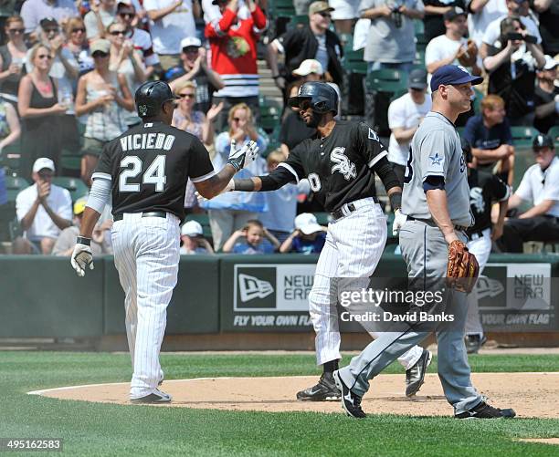 Alexei Ramirez of the Chicago White Sox is greeted by Dayan Viciedo after scoring as Eric Stults of the San Diego Padres stands nearby during the...