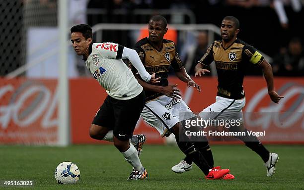 Jadson of Corinthians fights for the ball with Airton and Junior Cesar of Botafogo during the match between Corinthians and Botafogo for the...