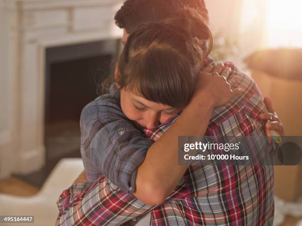 a couple in their new home hugging emotionally - chemise à carreaux photos et images de collection