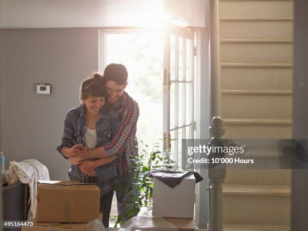 a couple hugging playfully in their new home - open day 10 stockfoto's en -beelden