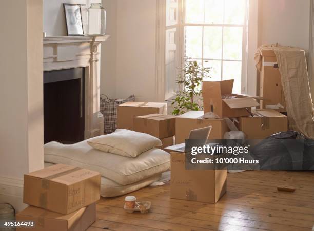 a room full of packing boxes and a laptop - new house imagens e fotografias de stock