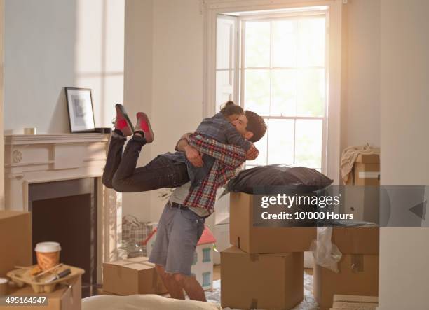 a couple celebrating moving in to a new home - changement de logement photos et images de collection