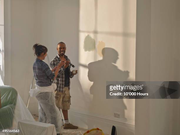 a man and woman doing diy in new home - couple painting bildbanksfoton och bilder
