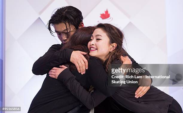 Alex Shibutan of the United States hugs his sister and parter Maia and their coach Marina Zueva after getting the results in the Ice Dance Free Dance...