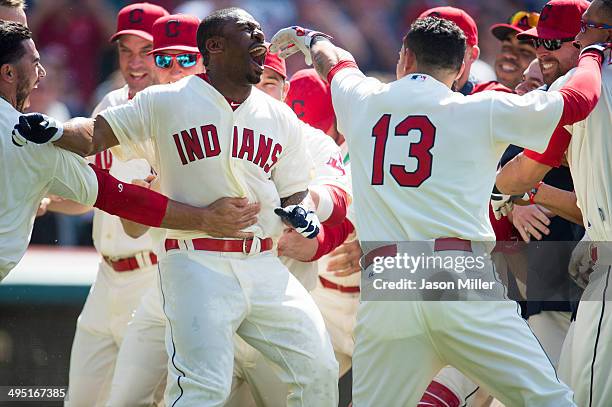 Michael Bourn of the Cleveland Indians celebrates with teammates after hitting a walk-off home run to defeat the Colorado Rockies during the ninth...