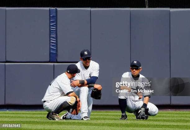 Brett Gardner, Jacoby Ellsbury and Ichiro Suzuki of the New York Yankees look on during a pitching change in the ninth inning against the Minnesota...