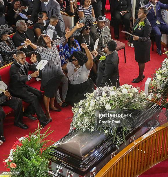 In this handout photo provided by the Palm Beach Post, A family member raises her hands as a worship song is performed during the funeral for Corey...