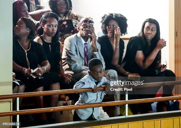 In this handout photo provided by the Palm Beach Post, A little boy watches the proceedings below from the balcony during the funeral for Corey Jones...