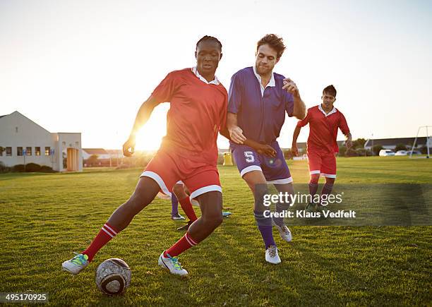 soccer players battling to get the ball - verteidiger fußball stock-fotos und bilder