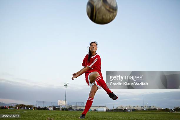 female soccer player kicking the ball over camera - football strip imagens e fotografias de stock