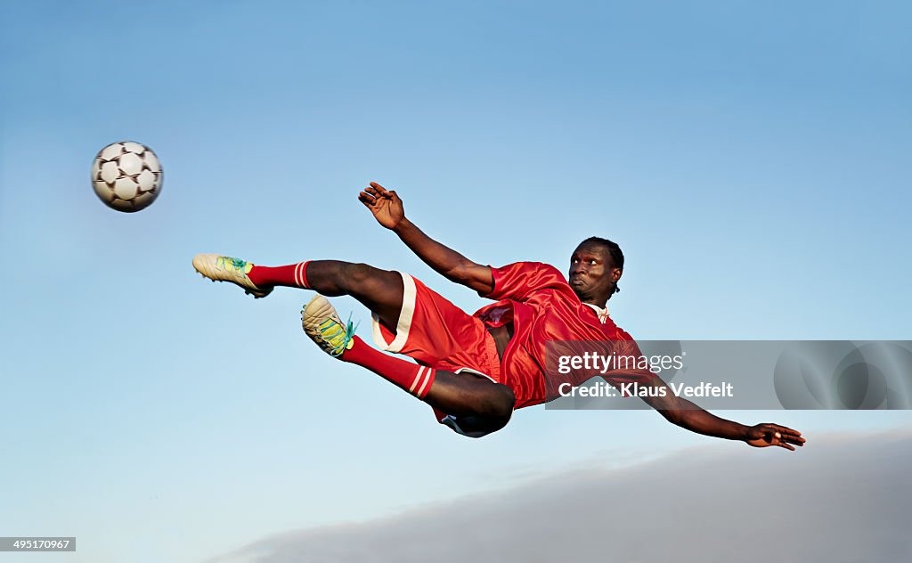 Football player about to kick ball in the air