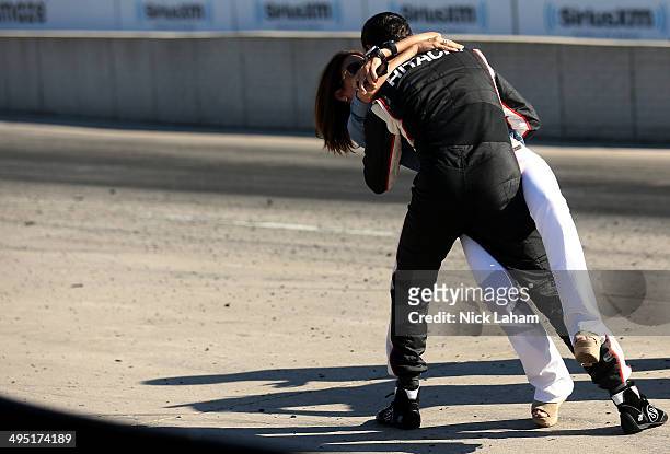 Helio Castroneves of Brazil, driver of the Team Penske Dallara Chevrolet celebrates winning with girlfriend Adriana Henao the Verizon IndyCar...