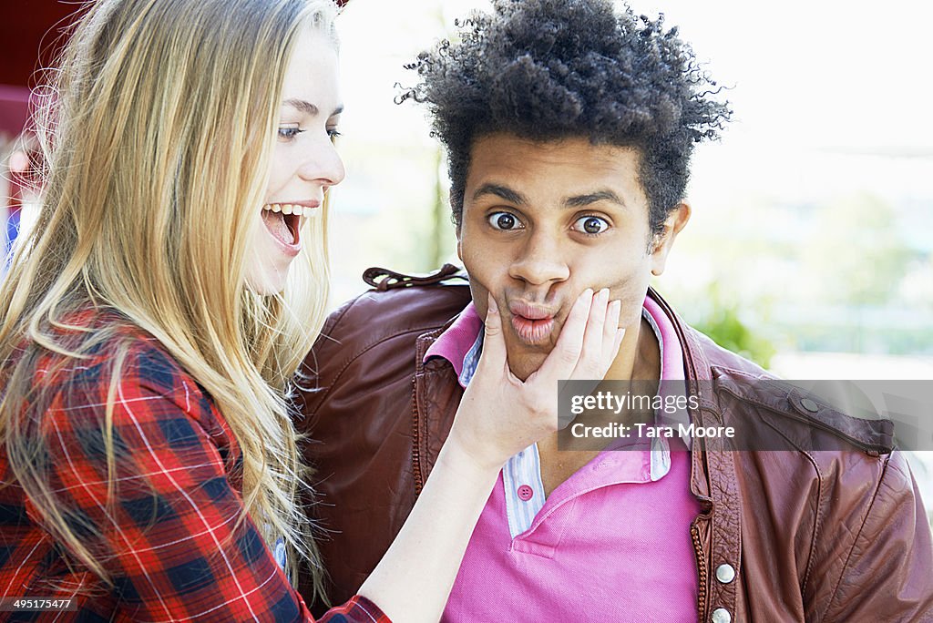 Young woman and man making silly face to camera