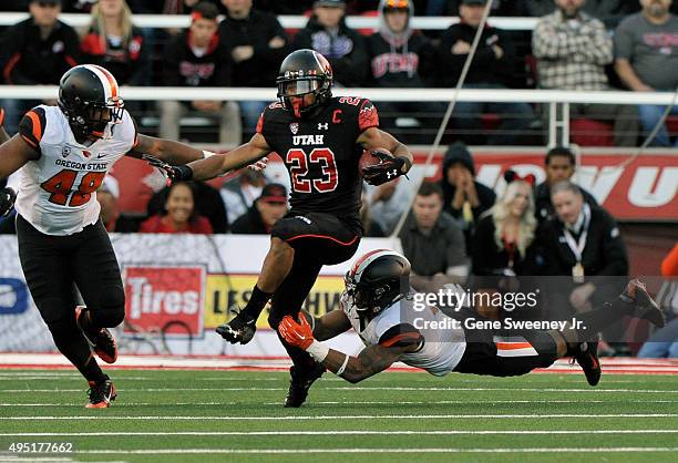 Devontae Booker of the Utah Utes runs for yardage in the first quarter between Jaswha James and Justin Strong of the Oregon State Beavers at...