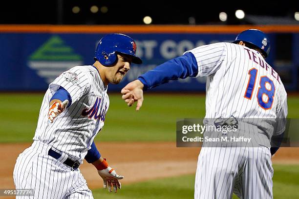 Michael Conforto of the New York Mets celebrates with third base coach Tim Teufel after hitting a solo home run in the third inning against the...