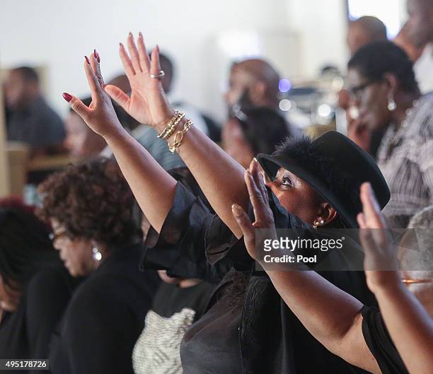 In this handout photo provided by the Palm Beach Post, People lift their hands as mnusic is played during the funeral for Corey Jones at Payne Chapel...