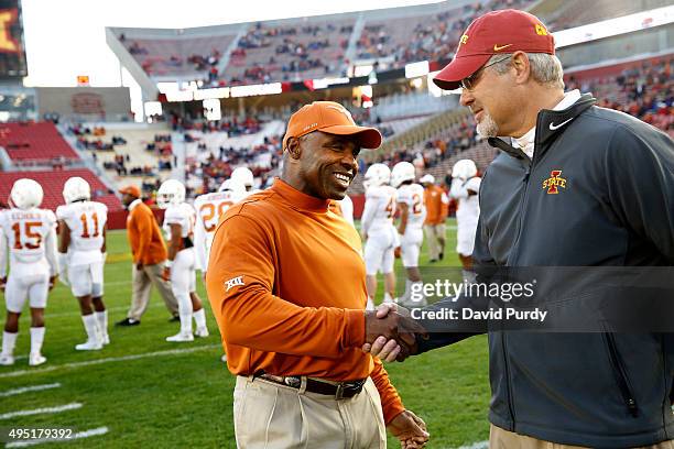 Head coach Charlie Strong of the Texas Longhorns and head coach Paul Rhoads of the Iowa State Cyclones shake hands at the fifty yard line during...