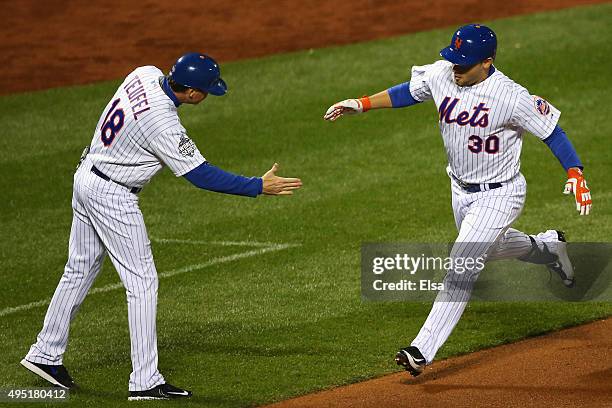 Michael Conforto of the New York Mets celebrates with third base coach Tim Teufel after hitting a solo home run in the fifth inning against the...