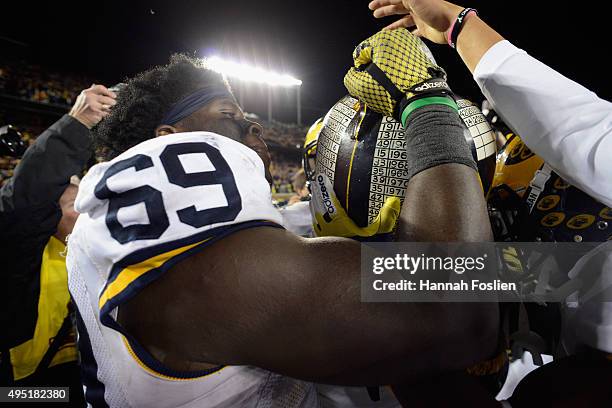 Willie Henry of the Michigan Wolverines passes the Little Brown Jug after winning the game against the Minnesota Golden Gophers on October 31, 2015...