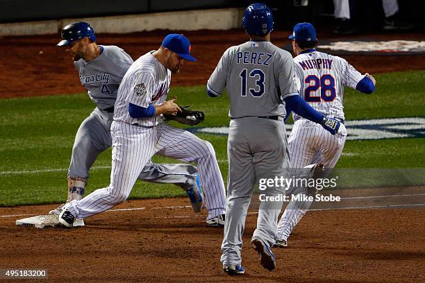 Daniel Murphy of the New York Mets flips the ball to first base after tagging Salvador Perez of the Kansas City Royals to complete the double play in...