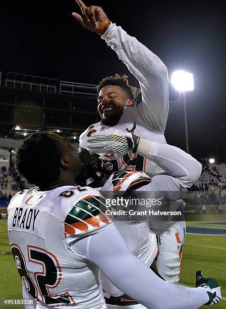 Corn Elder of the Miami Hurricanes celebrates with teammates after scoring the game-winning touchdown against the Duke Blue Devils during their game...