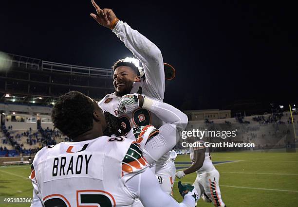 Corn Elder of the Miami Hurricanes celebrates with teammates after scoring the game-winning touchdown against the Duke Blue Devils during their game...