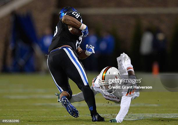 Corn Elder of the Miami Hurricanes dives to tackle Jela Duncan of the Duke Blue Devils during their game at Wallace Wade Stadium on October 31, 2015...