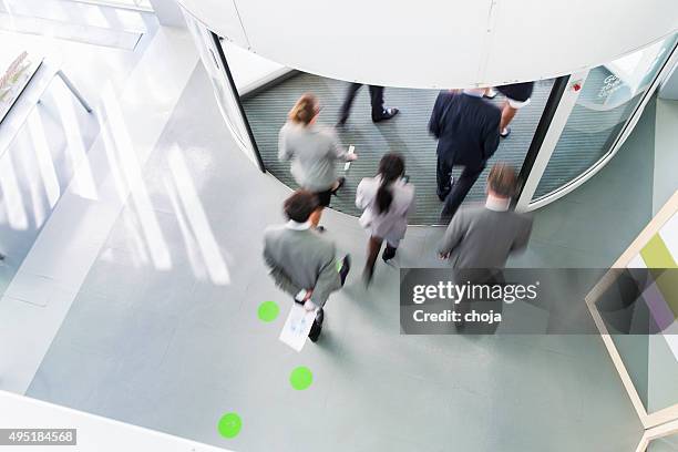 group of ofiice worker entering through revolving door - revolving door stock pictures, royalty-free photos & images