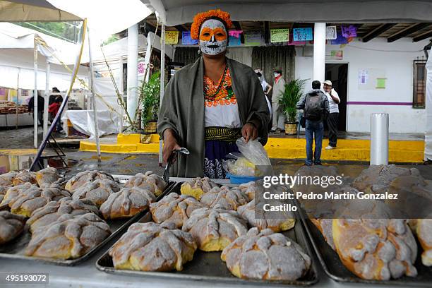 Woman poses near the traditional "pan de muerto" during the Day of The Dead at Panteon Municipal on October 31, 2015 in Capula, Mexico. The three-day...