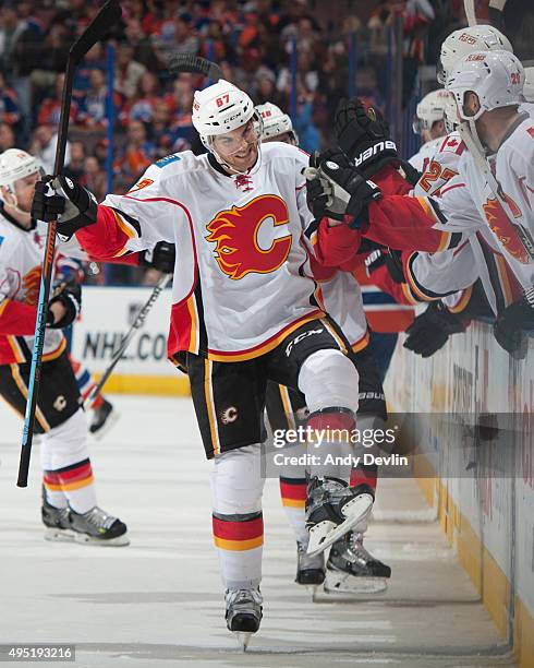 Michael Frolik of the Calgary Flames is congratulated by teammates on the bench after scoring a game winning goal against the Edmonton Oilers on...