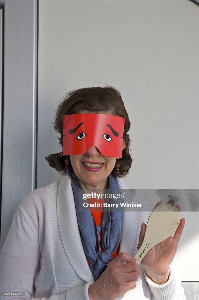 Red paper cut-out mask on smiling woman