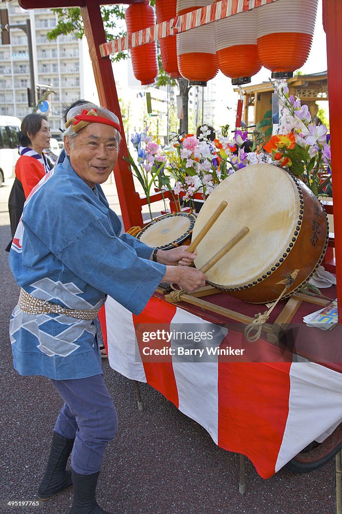 Man in traditional costume beating drums