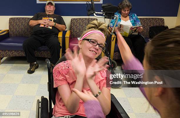 Morgan Brittain plays a hand game with her cousin Hannah Terry while waiting for a physical appointment at the Childrens Development and...