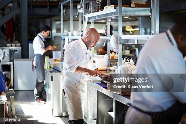 chef cutting fish at kitchen in restaurant - restaurateur photos et images de collection