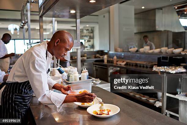 chef preparing dish at restaurant - black cook stockfoto's en -beelden