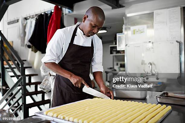 male chef preparing food at restaurant - black chef stock pictures, royalty-free photos & images