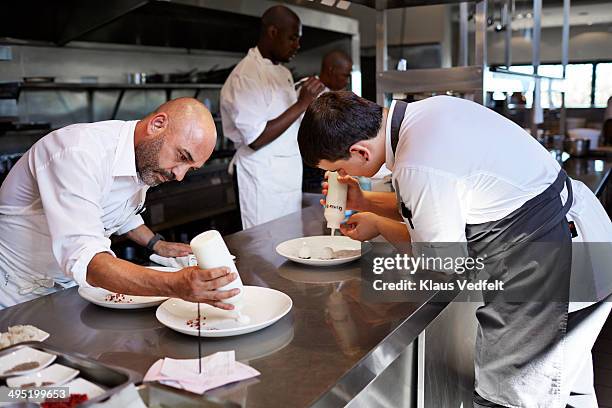 chefs preparing food in kitchen at restaurant - chef cuisinier sauce photos et images de collection