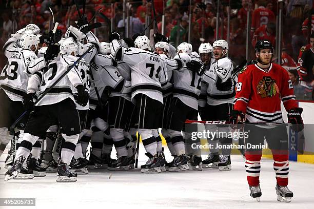 Ben Smith of the Chicago Blackhawks skates away as the Los Angeles Kings celebrate after defeating the Blackhawks 5 to 4 in overtime in Game Seven to...