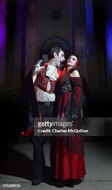 Revellers dressed as a vampire couple pose for photographs as they arrive for a Gothic Ball taking place inside a former church on October 31, 2015...