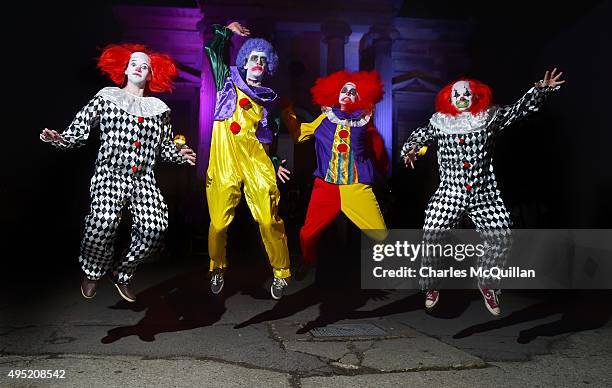 Revellers dressed as clowns pose for photographs as they arrive for a Gothic Ball taking place inside a former church on October 31, 2015 in...
