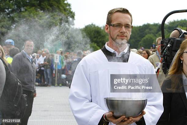 An altar server carries a bowl with burning incest from the altar to be used to incense the congregation at the closing mass of the 99th Deutscher...