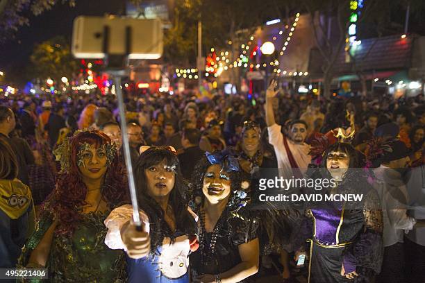 People use a selfie stick to photograph themselves at the Halloween Carnaval on October 31, 2015 in West Hollywood, California. Carnaval officials...