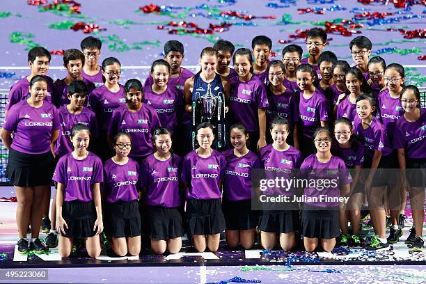 Agnieszka Radwanska of Poland poses with the Billie Jean King Trophy and the tournament ball kids after defeating Petra Kvitova of Czech Republic in...