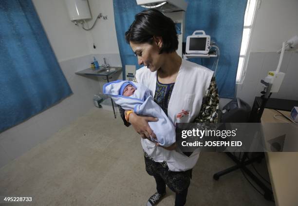 Medic takes care of a newborn Syrian refugee baby at a clinic managed by the French non-governmental organisation, Medecins Sans Frontieres , in the...