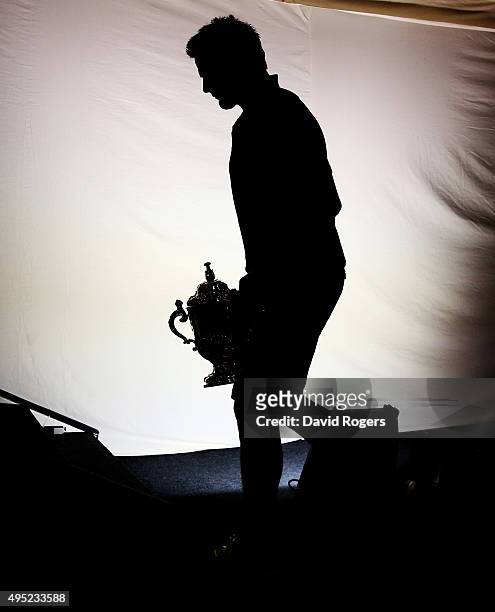 Silhouette of Richie McCaw, the All Black captain, as he walks onto the podium carrying the Webb Ellis Cup during the New Zealand All Blacks press...